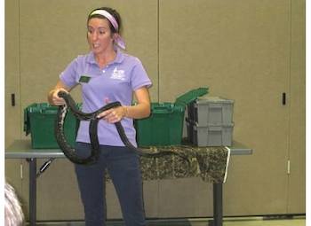 student intern at sandy creek handles snake 